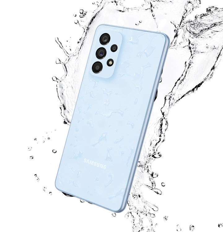Galaxy A53 5G in Awesome Blue, seen from the rear with water splashing around it.