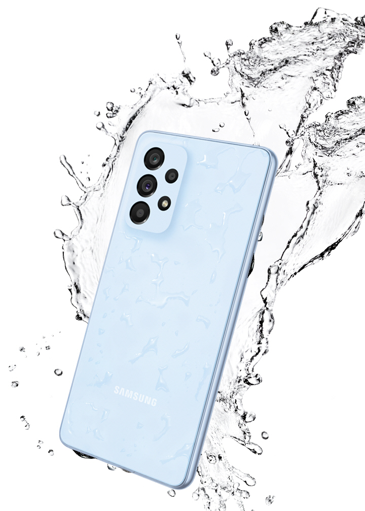 Galaxy A53 5G in Awesome Blue, seen from the rear with water splashing around it.