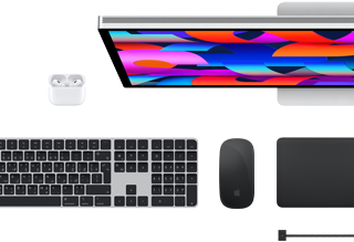 لقطة علوية تعرض مجموعة من اكسسوارات Mac‏: شاشة Studio Display، ولوحة مفاتيح ماجيك، وماجيك ماوس، ولوحة تعقب ماجيك، وAirPods‏، وكابل شحن MagSafe‏