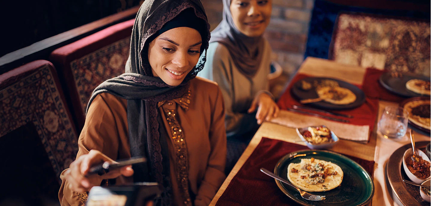 The woman is touching her smartphone to the card reader.